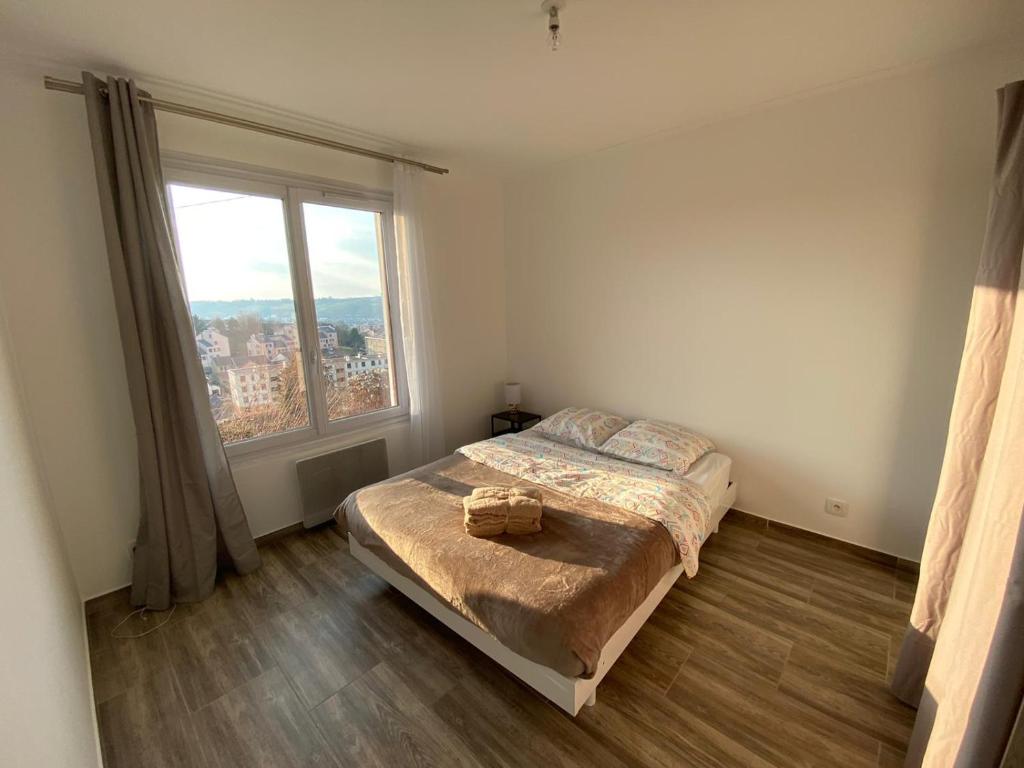 een slaapkamer met een bed en een groot raam bij Maison entière avec jardin et une belle vue in Évreux