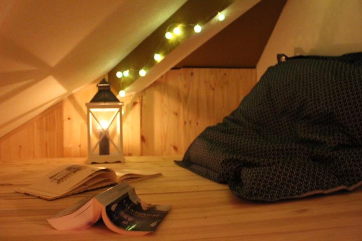 a book and a lamp on the floor next to an attic at Studio de charme en plein centre ville in Beauvais