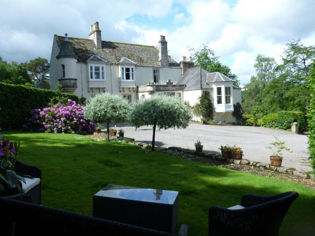 une maison avec une pelouse devant elle dans l'établissement Craigellachie Lodge, à Craigellachie