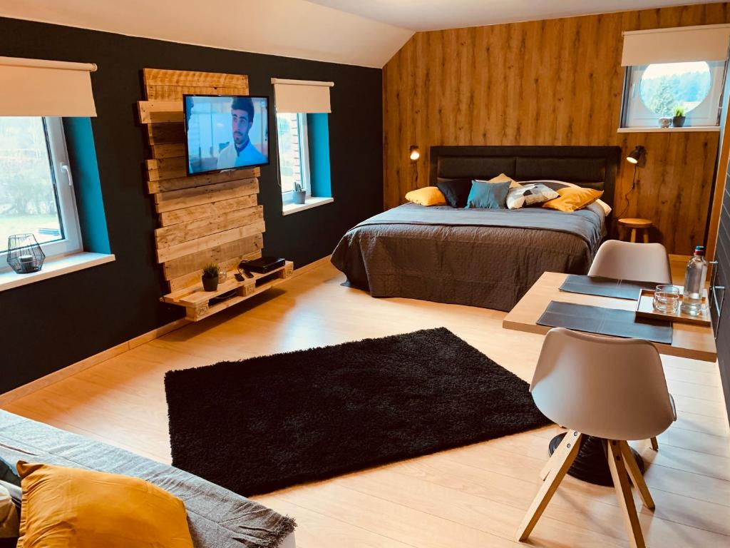 um quarto com 2 camas e uma televisão na parede em La Chambre d'en Haut em La Reid