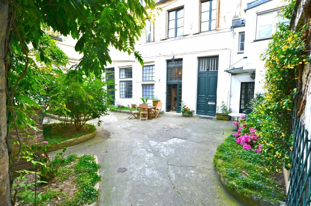 a courtyard of a white building with a table and chairs at Fenetre sur Cour in Paris