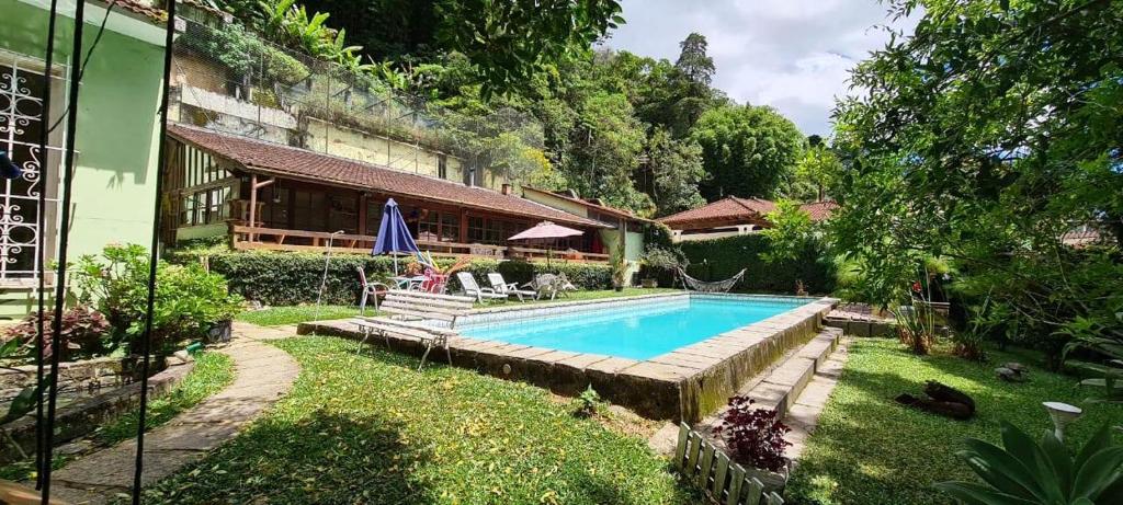a swimming pool in the backyard of a house at Pousadinha Lá em Casa in Petrópolis