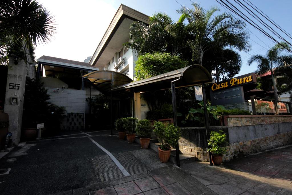 a restaurant with potted plants in a parking lot at Casa Pura Inn and Suites in Manila
