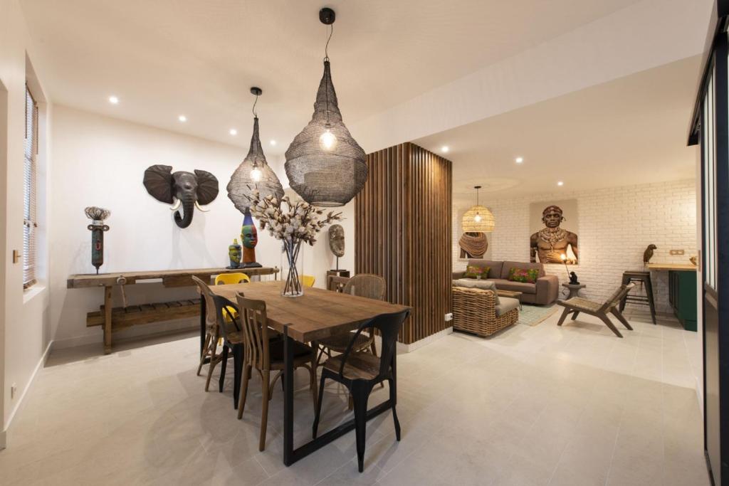 a dining room and living room with a table and chairs at Out of Africa in Paris