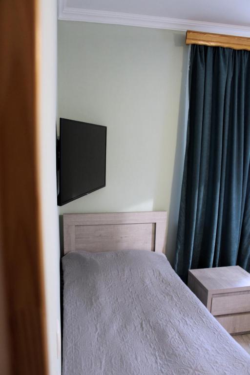 a bedroom with a bed and a flat screen tv at Guest House on Meskheti in Borjomi