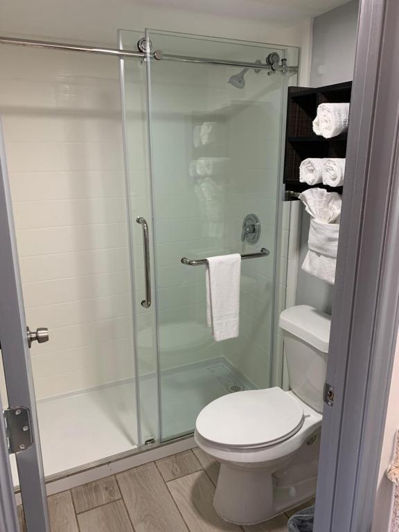 ein Badezimmer mit Toilette und Glasdusche in der Unterkunft South Padre Island Lodge in South Padre Island
