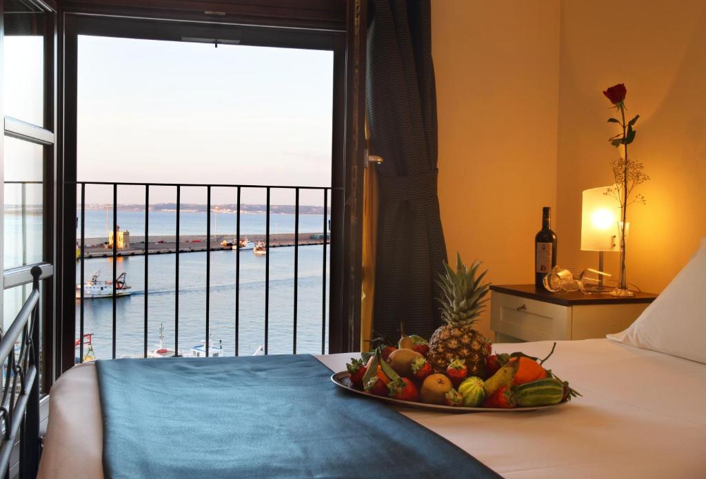 a bed sitting on top of a wooden table next to a window at Al Pescatore Hotel & Restaurant in Gallipoli