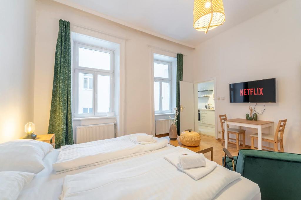 sypialnia z 2 łóżkami, stołem i biurkiem w obiekcie Seraphina I levestate w Wiedniu