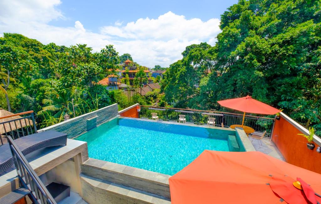 a swimming pool with an orange umbrella and an orange umbrella at Bali Ubud Harmony in Ubud