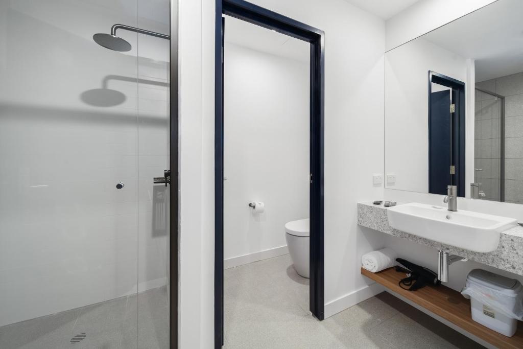 a white bathroom with a sink and a toilet at Springs Newcastle in Newcastle