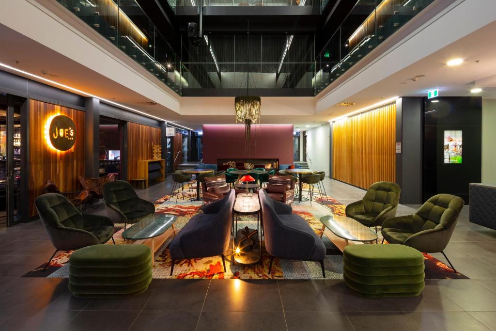 vestíbulo con sillas y mesa en una habitación en East Hotel and Apartments, en Canberra