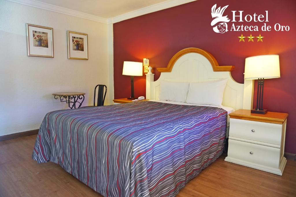 ein Hotelzimmer mit einem Bett und einem amerikanischen Zwiebelschild des Hotels in der Unterkunft Hotel Azteca de Oro Mexicali in Mexicali