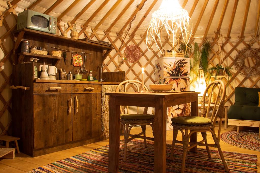 jadalnia ze stołem i krzesłami w jurcie w obiekcie 2 CUORI E 1 YURTA Glamping in Tuscany - Adults Only w mieście Asciano