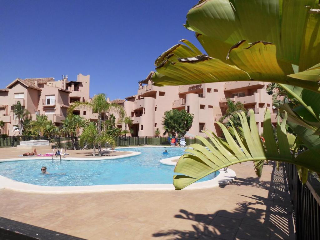 a swimming pool in a resort with people in it at Coming Home - Mar Menor Resort in Torre-Pacheco