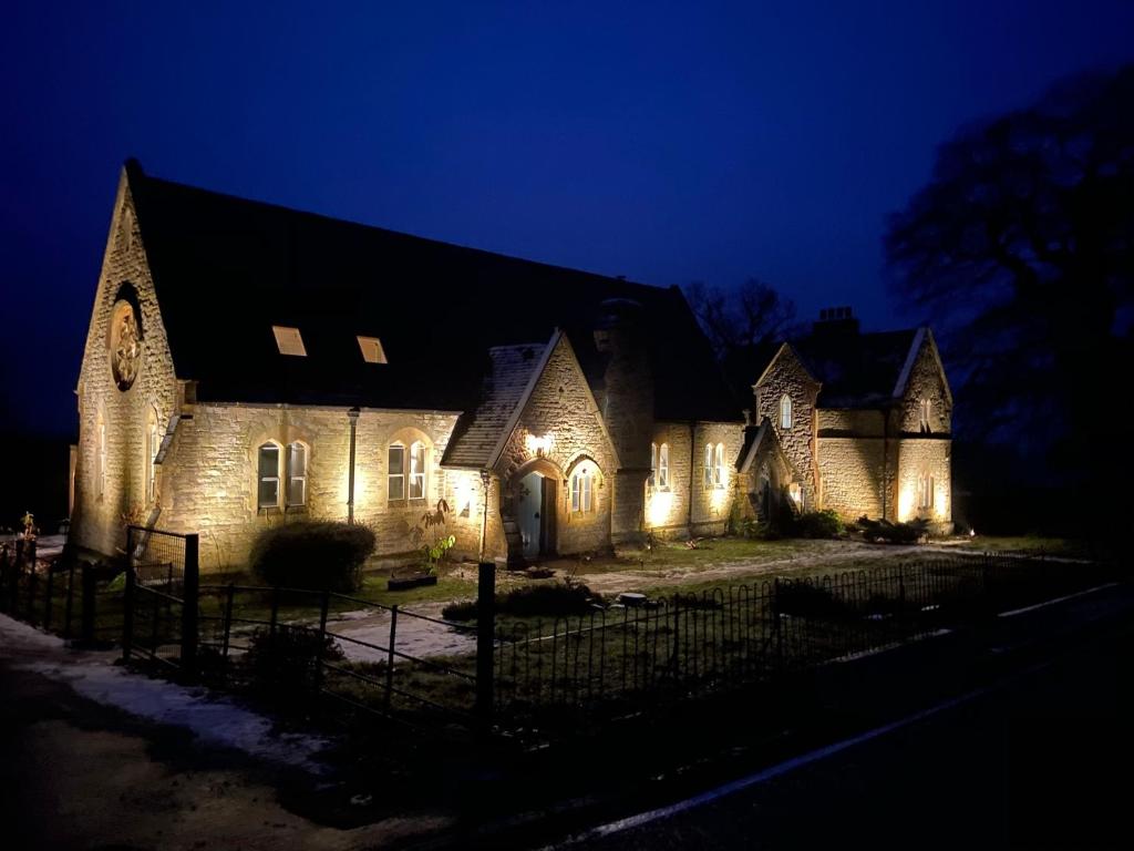 uma casa com luzes na frente à noite em The Old Kitchen em Burwarton