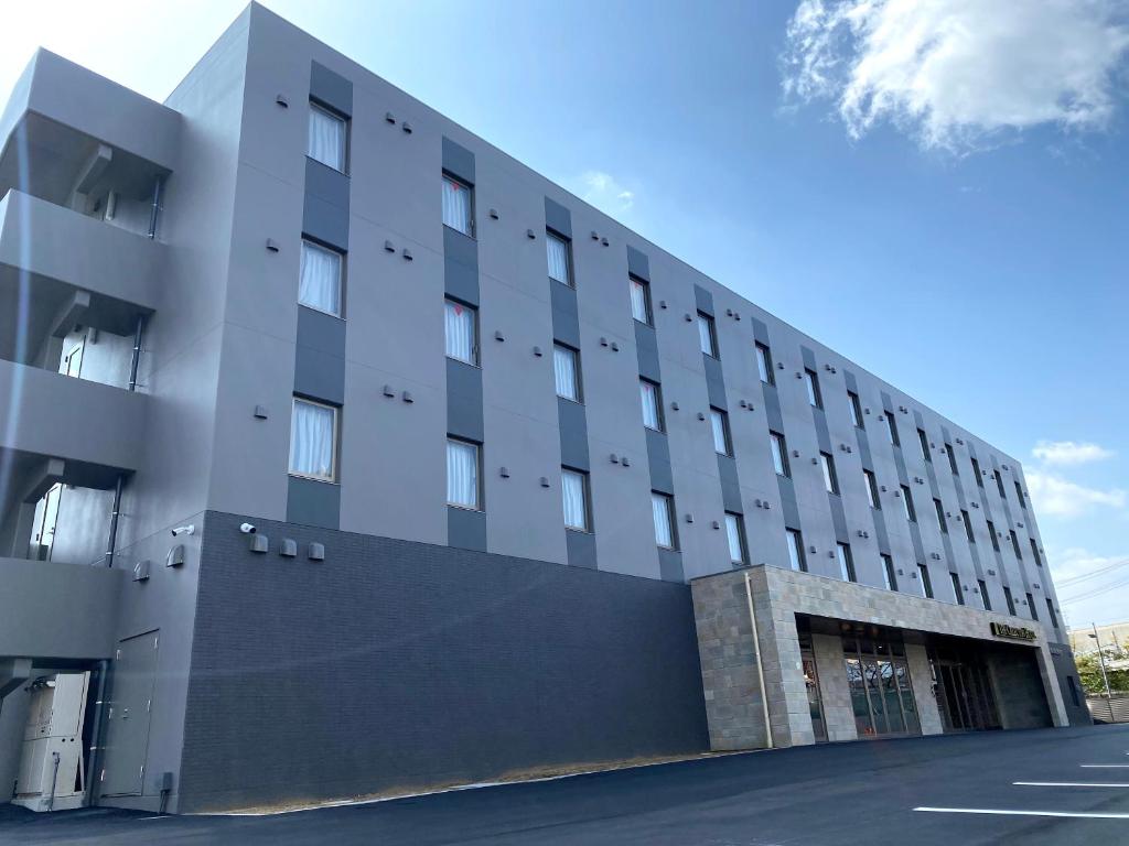 un grand bâtiment avec un parking en face de celui-ci dans l'établissement The CELECTON Abeno-Matsubara Ekimae, à Matsubara