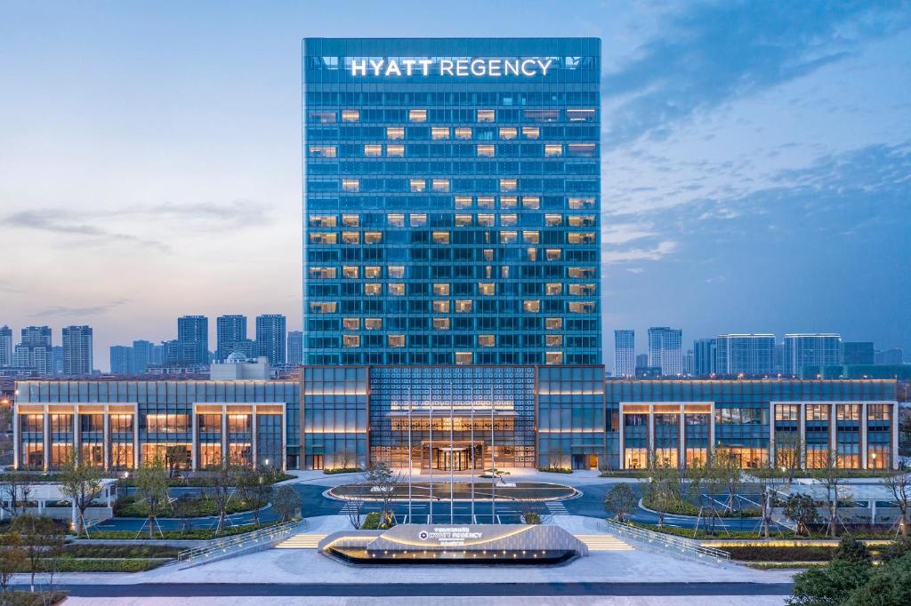 a tall building with a sign on the side of it at Hyatt Regency Ningbo Hangzhou Bay in Ningbo
