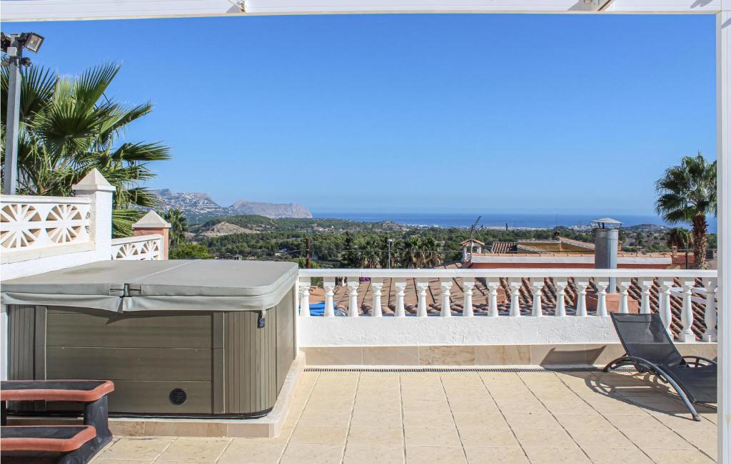 a patio with a barbecue grill on a balcony at Awesome Home In Tosal With Jacuzzi in La Nucía