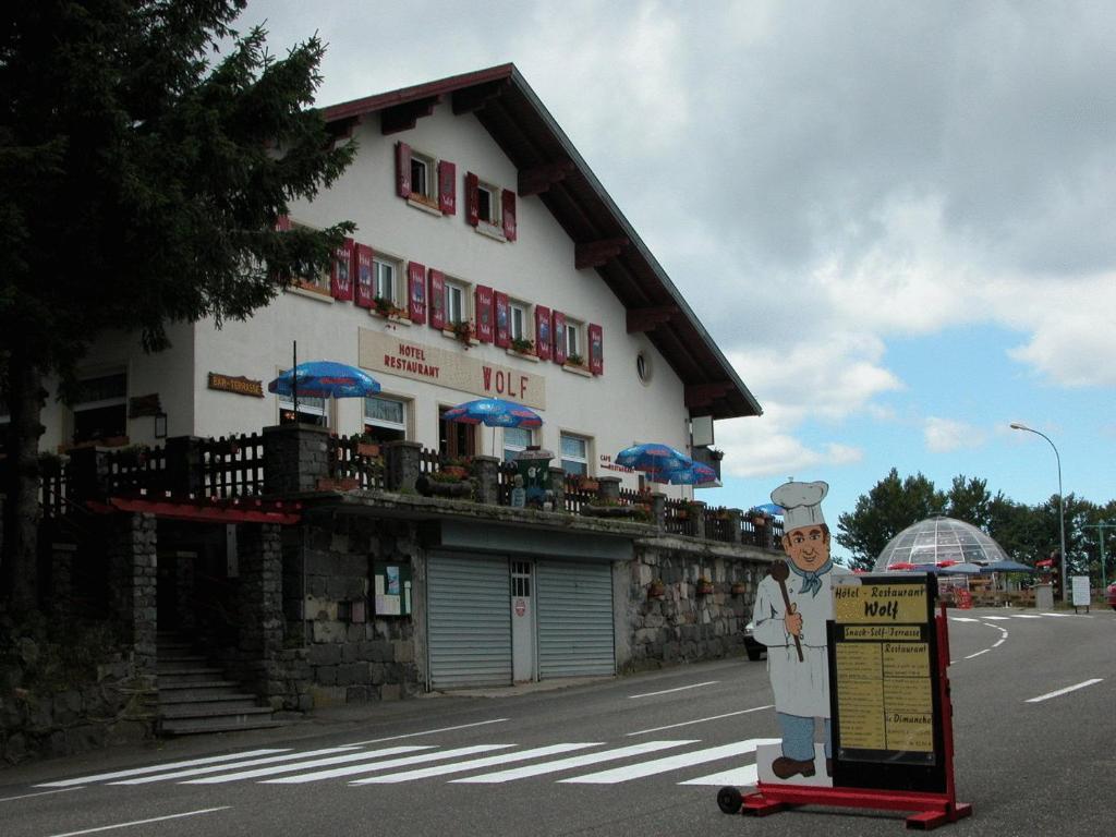 uma estátua de um chef de pé em frente a um edifício em Hôtel Restaurant Wolf em Markstein 