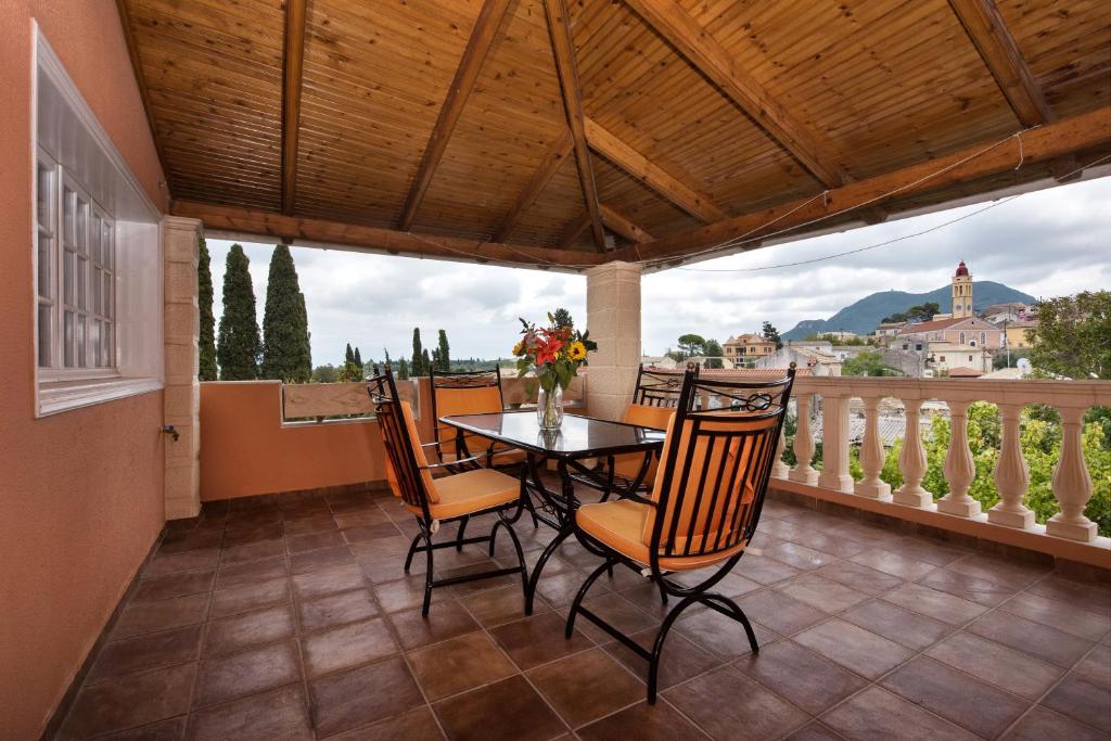a dining room with a table and chairs on a balcony at The Old Mansion in Sinarádes