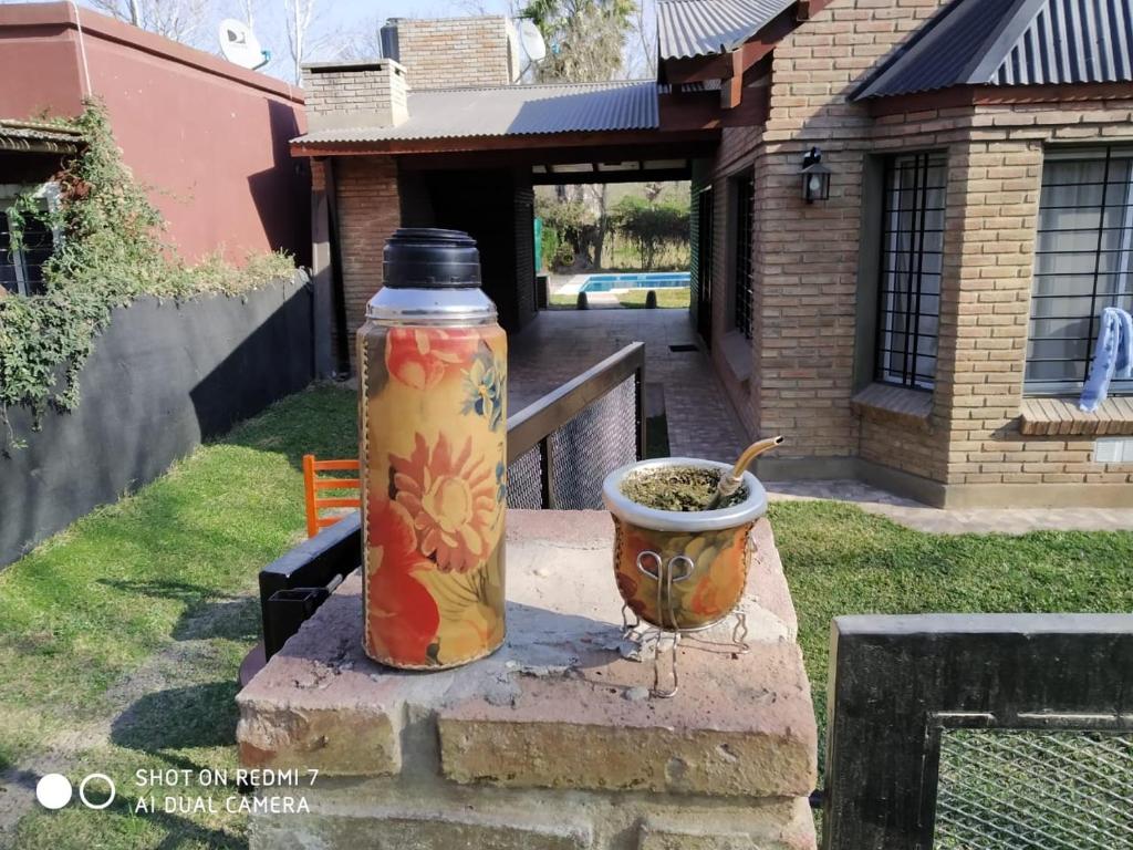 a bottle and a pot sitting next to a house at CASA FUNES in Funes