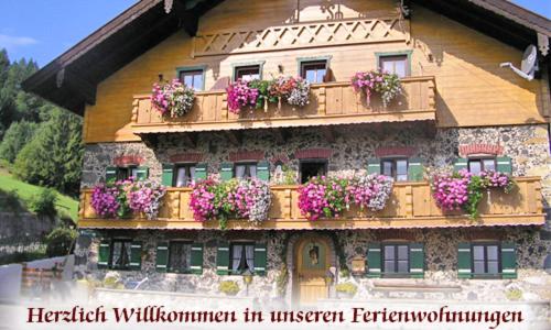 un edificio con cajas de flores en su lado en Bernerhof Ferienwohnungen Schmuck, en Teisendorf
