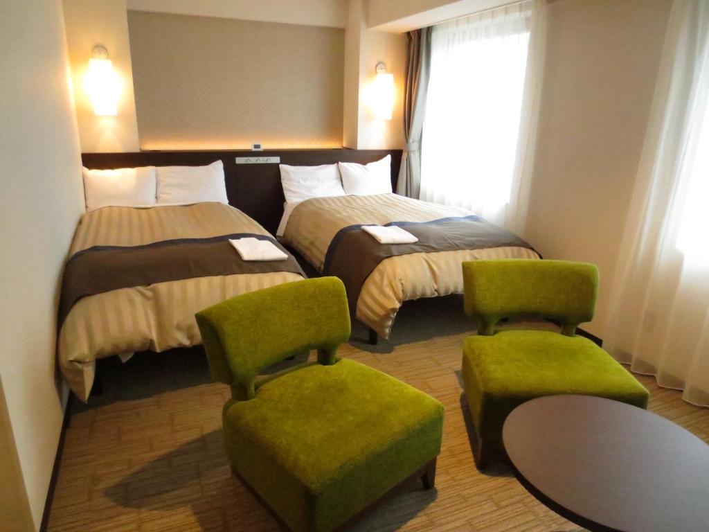 Postel nebo postele na pokoji v ubytování Kochi Hotel
