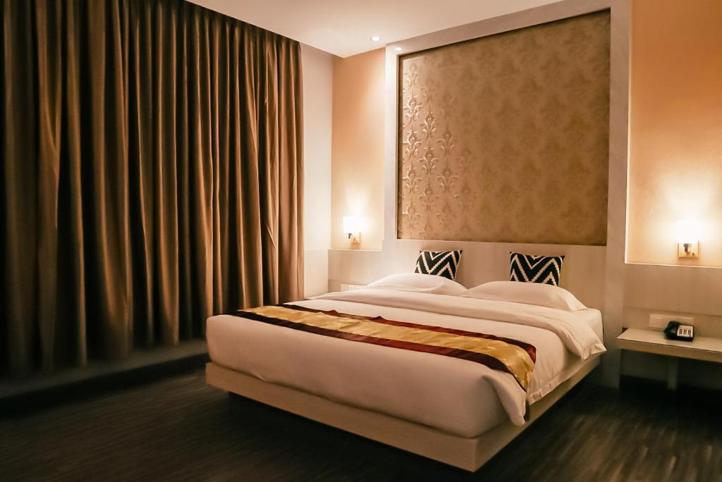 a bedroom with a large bed in a room at Grand Sydney Hotel in Batam Center