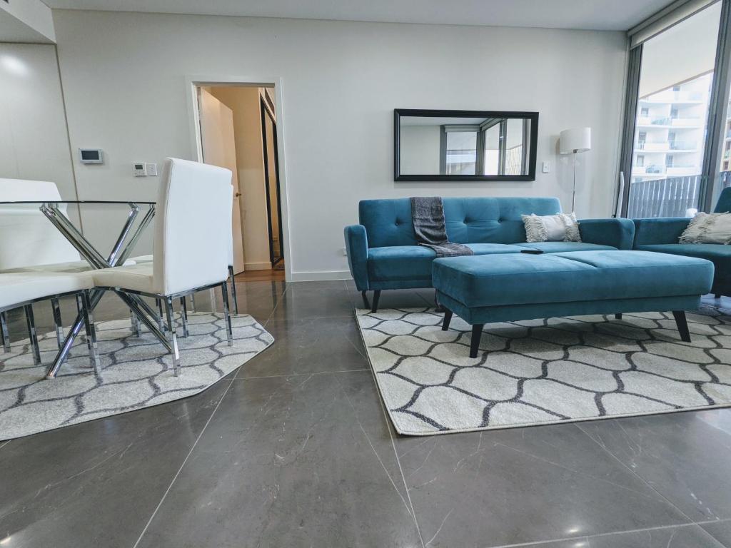Una sala de estar con un sofá azul y una mesa. en Elegant 3-bed 2-bath, balcony, with pool included, NO PARTIES!, en Sídney