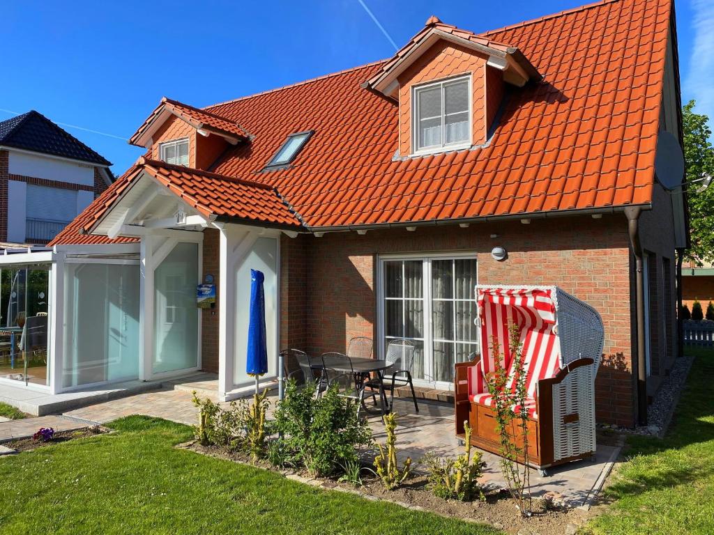 ein Haus mit einem orangenen Dach und einer Terrasse in der Unterkunft Ferienhaus Marina in Boltenhagen
