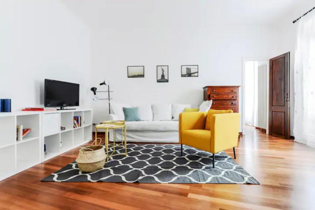 ミラノにあるPagano & Cenacolo Bright Apartmentのリビングルーム(ソファ、黄色の椅子付)