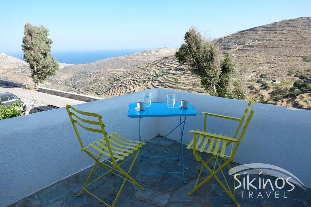a blue table and two chairs on a balcony at Sikinos Elegant Studio in Síkinos