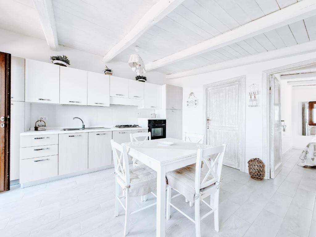 カステルサルドにあるAppartamento La Palmaの白いキッチン(白いテーブルと椅子付)