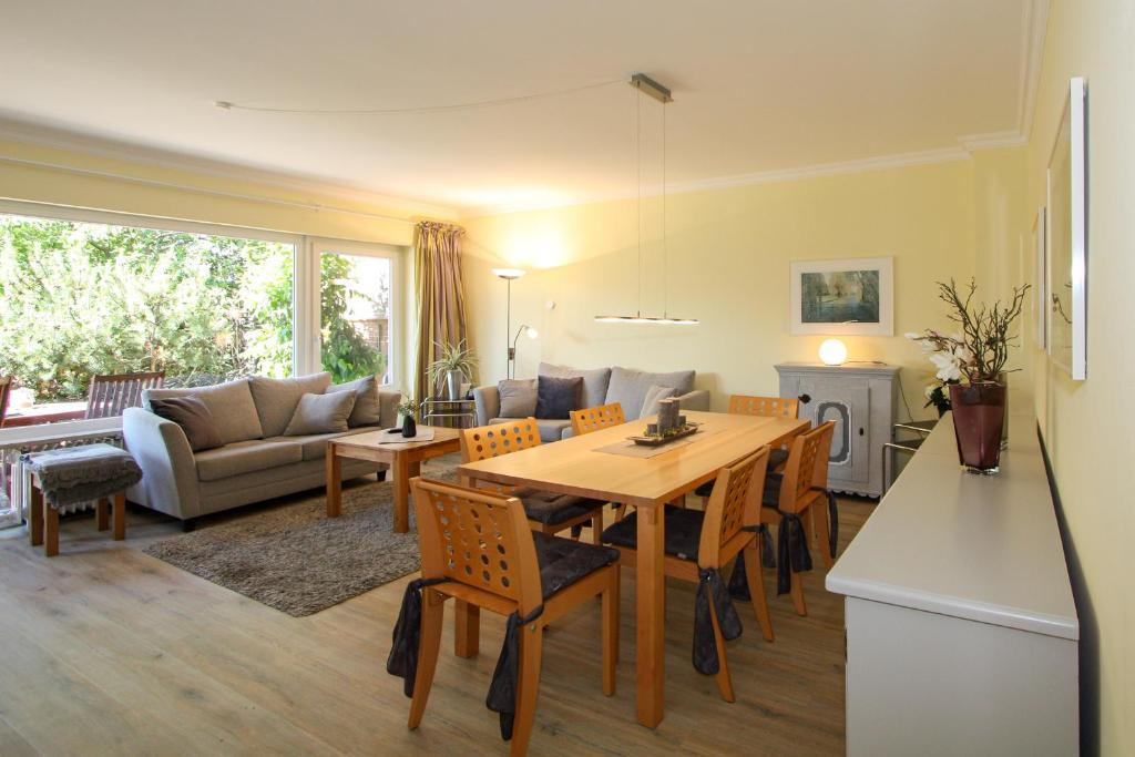 a kitchen and living room with a wooden table and chairs at Strandhaus Helene in Wenningstedt