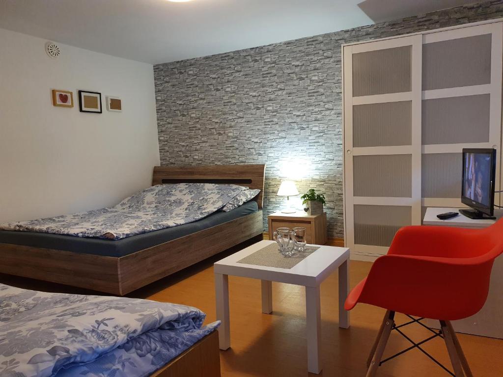 1 dormitorio con 2 camas, mesa y silla en Willa SOL en Mielno