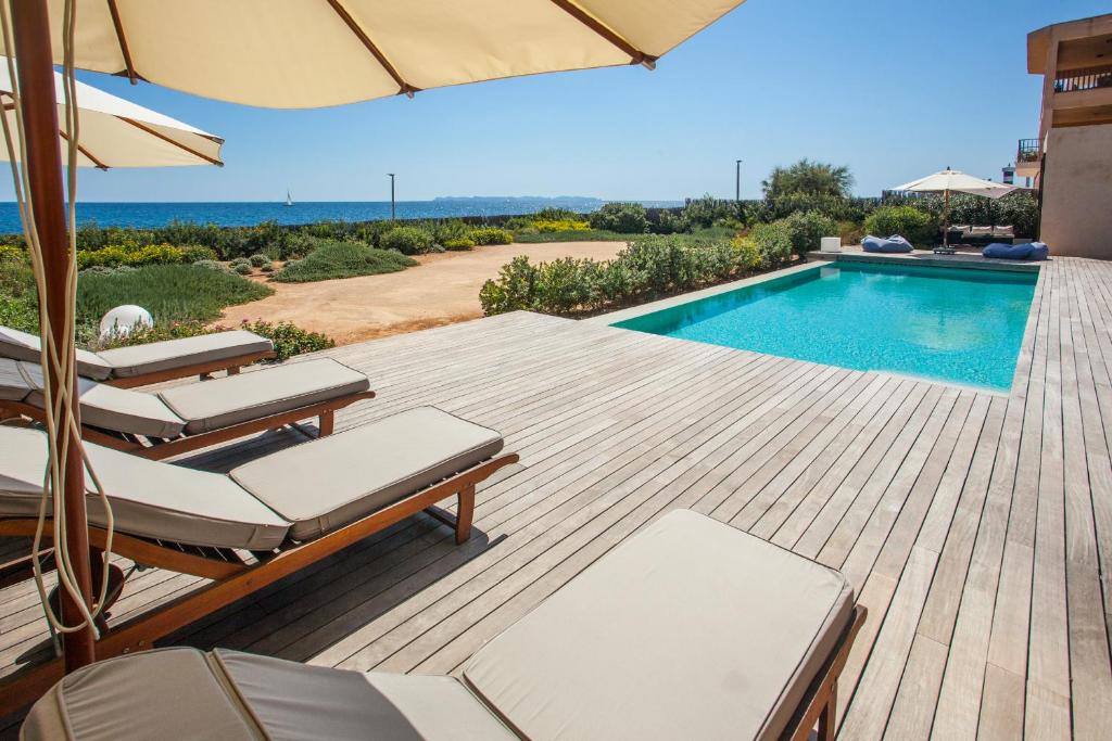a deck with chairs and a swimming pool at Villa Cabrera loft in Colonia Sant Jordi