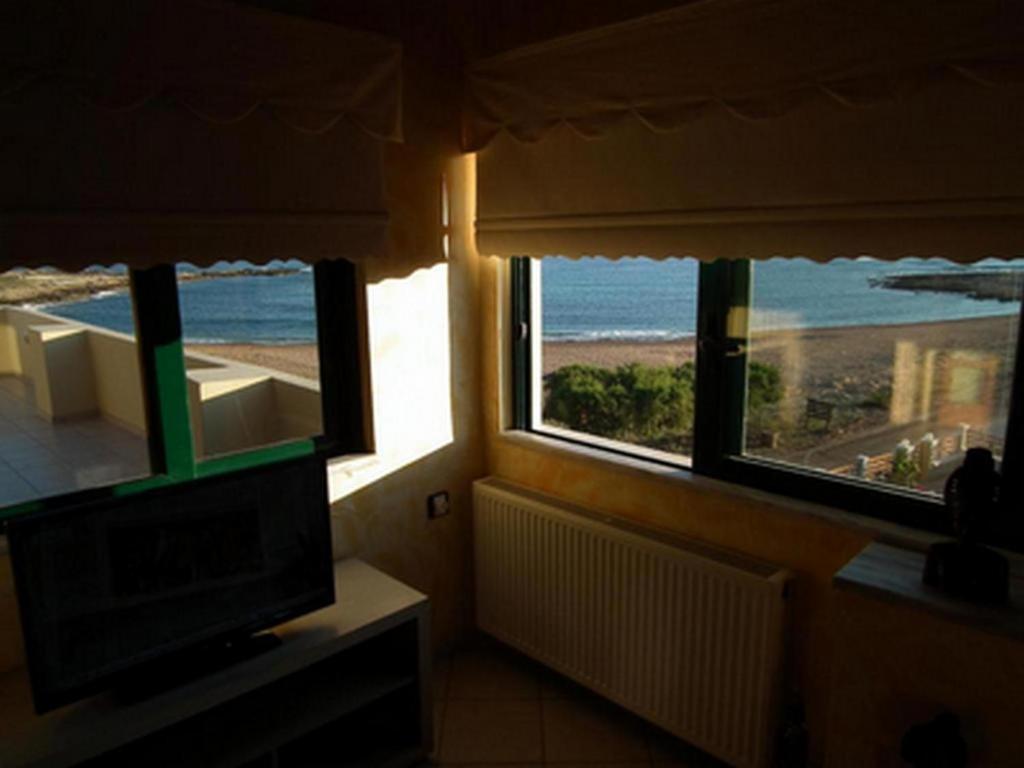 a room with a television and a view of the beach at Gramvoussa Bay in Kissamos