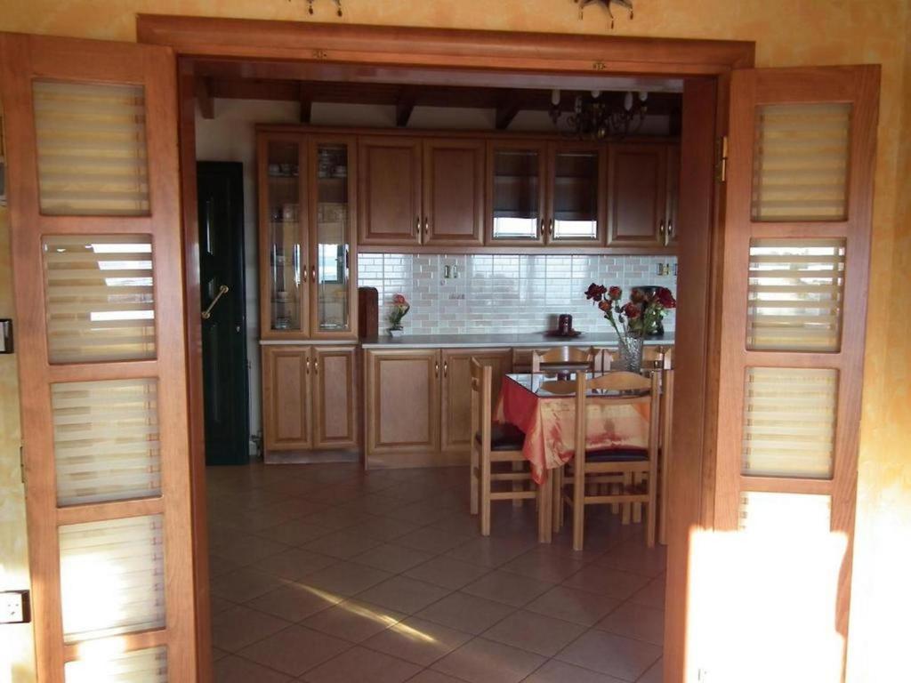 a kitchen with wooden cabinets and a table with chairs at Gramvoussa Bay in Kissamos