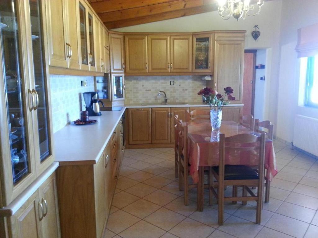 a kitchen with wooden cabinets and a table with a vase of flowers at Gramvoussa Bay in Kissamos