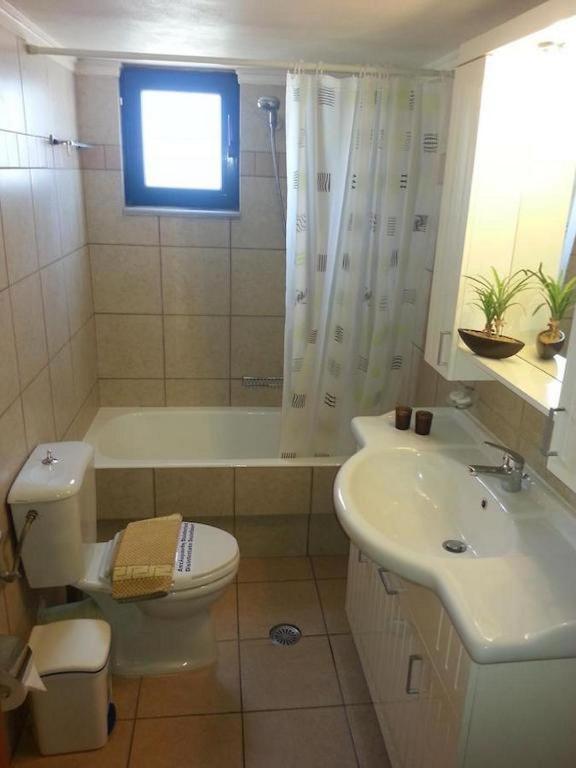 a bathroom with a toilet and a tub and a sink at Gramvoussa Bay in Kissamos