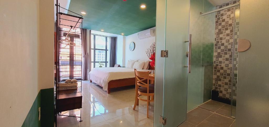 a bedroom with a bed and a table in a room at Gemini Saigon CENTER in Ho Chi Minh City
