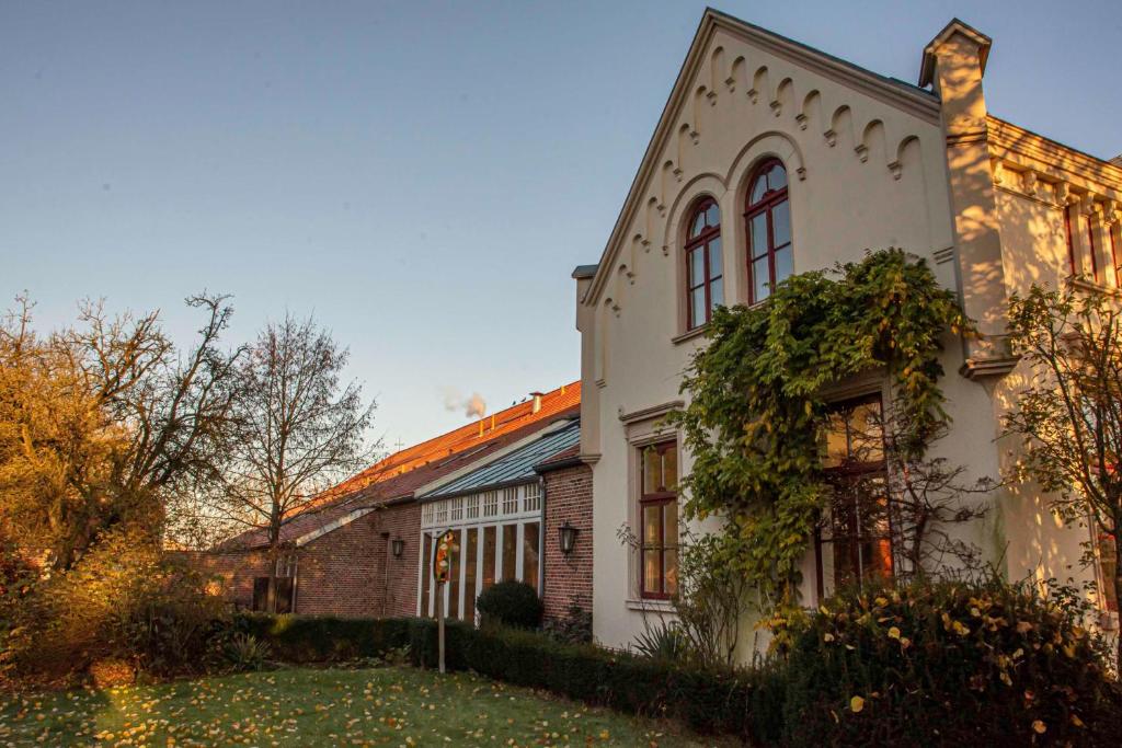 een wit huis met een bakstenen gebouw bij Wiemannshof 25191 in Bunde