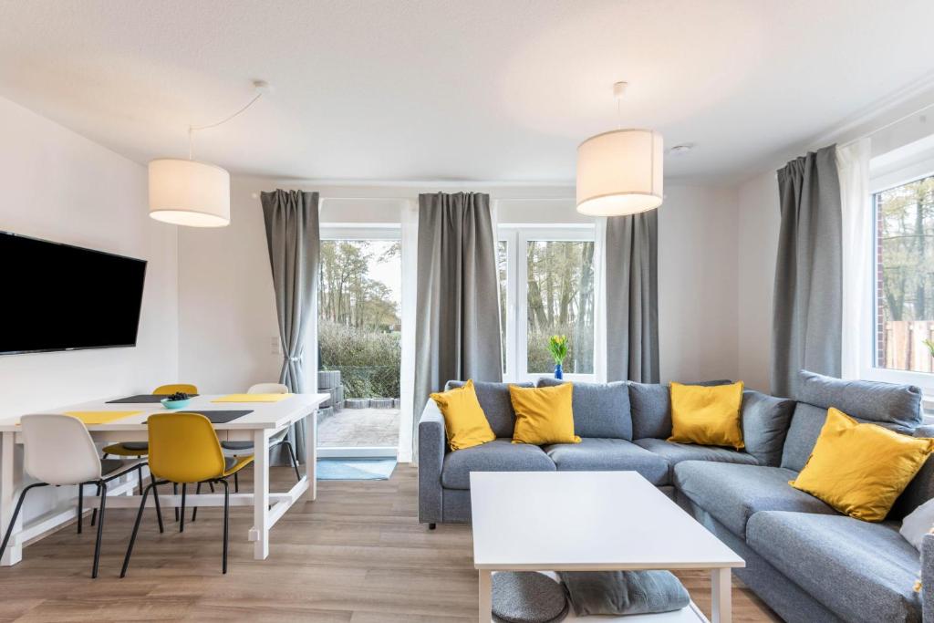 sala de estar con sofá azul y almohadas amarillas en Haus Hein Mück, en Norddeich