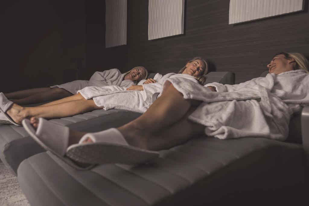 a group of three people laying on a bed at Formby Hall Golf Resort & Spa in Southport