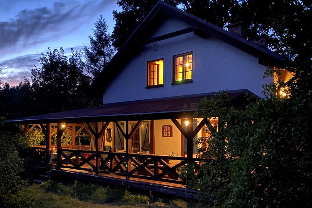 dom z oświetleniem w oknach w nocy w obiekcie Ostoja Miłolas w Lidzbarku Warmińskim