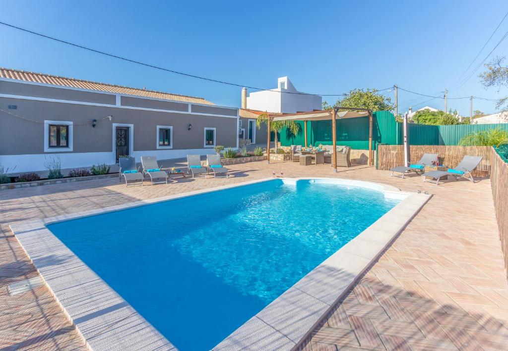 a swimming pool in front of a house at Villa Arade in Silves