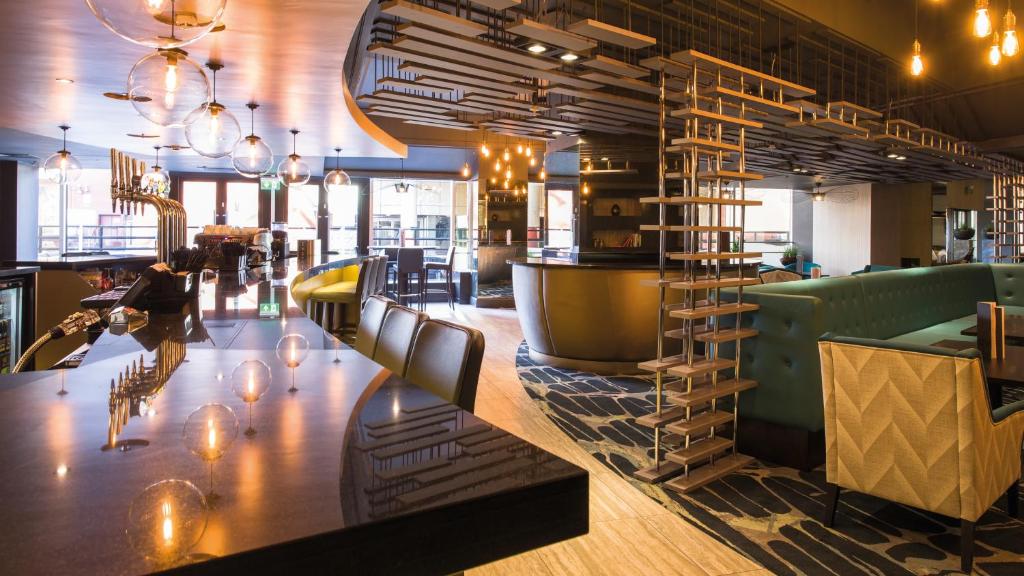 a restaurant with a large wooden table and chairs at Crowne Plaza Harrogate by IHG in Harrogate
