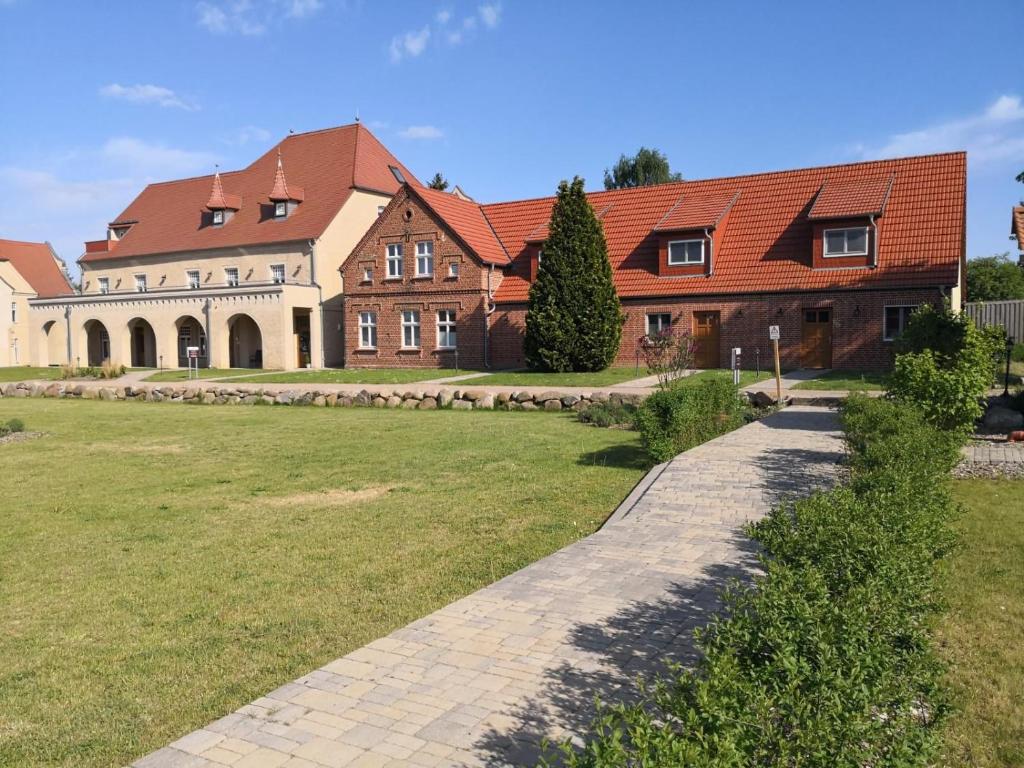 ein großes Haus mit einem Rasenplatz davor in der Unterkunft Der Westflügel Hofmaler WF-53 in Stolpe auf Usedom