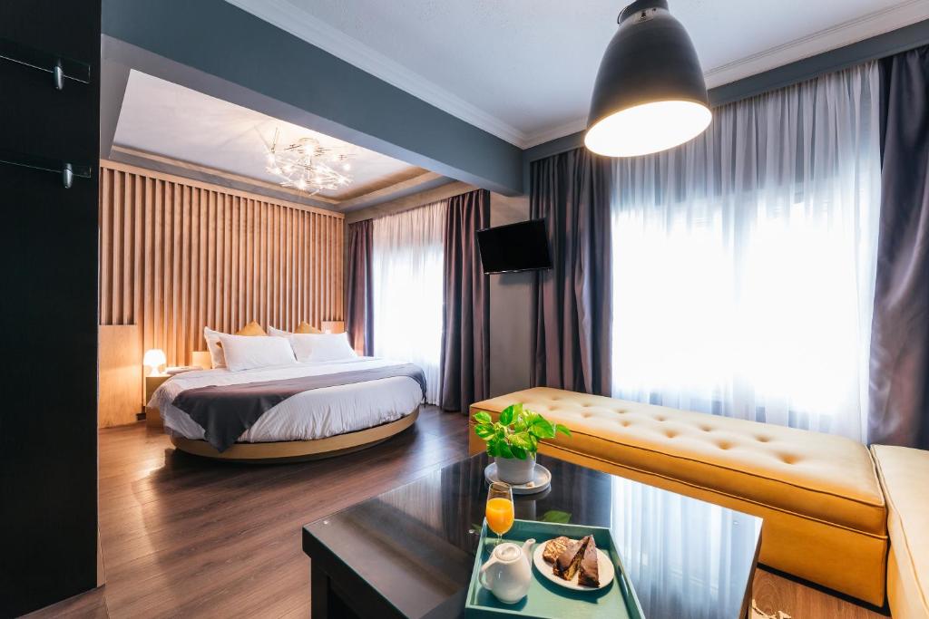 Habitación de hotel con cama, sofá y mesa en Ladadika Design, Philian Hotels and Resorts, en Tesalónica