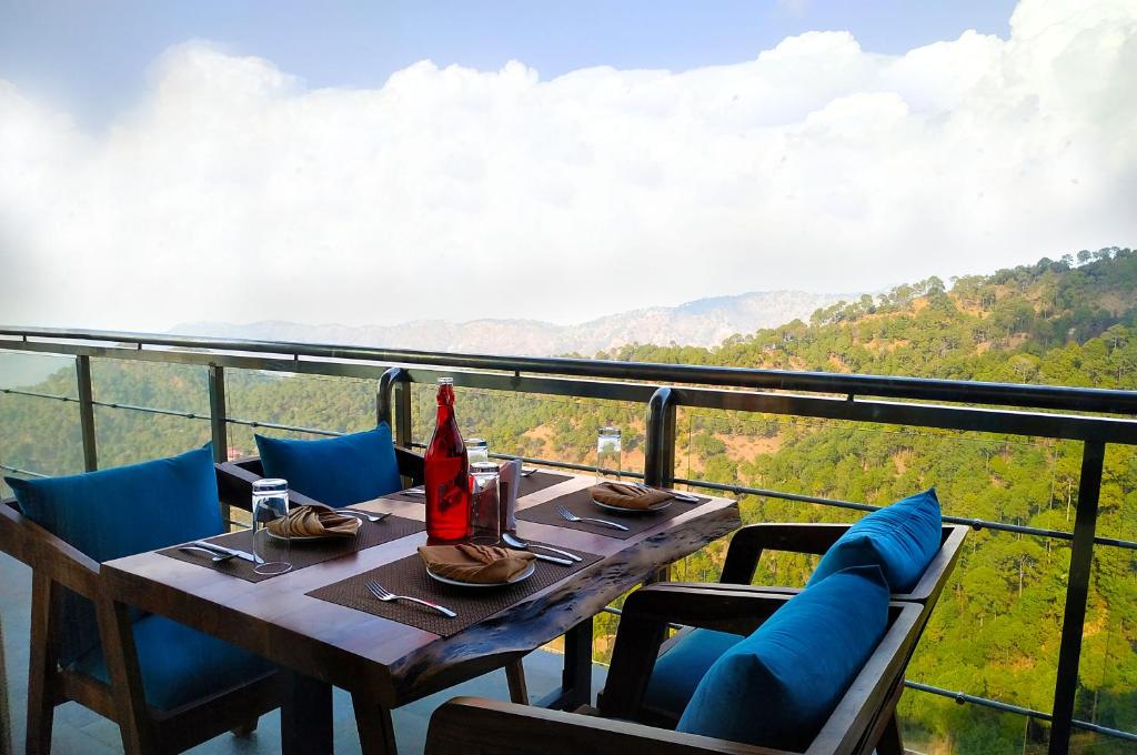 a table and chairs with a view of the mountains at Lemon Tree Hotel, Kasauli in Kasauli